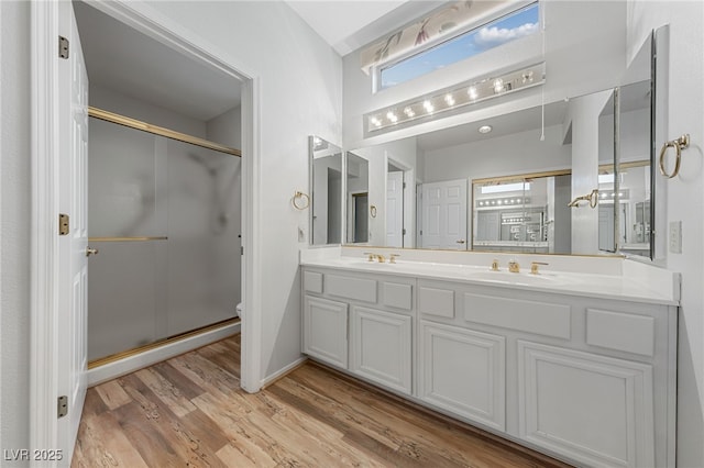 9917 Arbuckle Dr, Las Vegas, NV 89134 - full bathroom featuring a shower stall, wood finished floors, toilet, double vanity, and baseboards