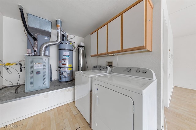 9917 Arbuckle Dr, Las Vegas, NV 89134 - laundry room featuring strapped water heater, cabinet space, washing machine and clothes dryer, light wood finished floors, and heating unit