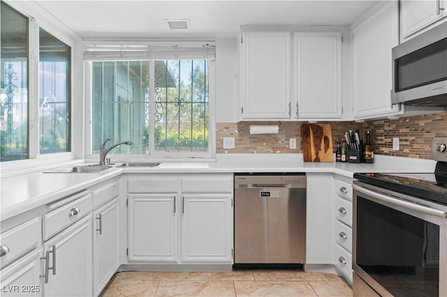 2479 Domingo St, Las Vegas, NV 89121 - kitchen with stainless steel appliances, tasteful backsplash, white cabinetry, and light countertops