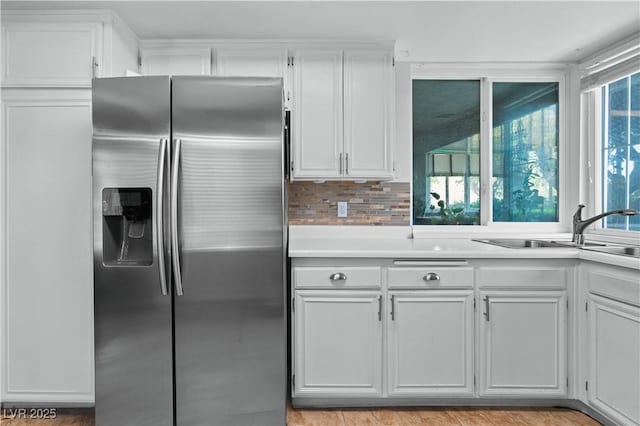 2479 Domingo St, Las Vegas, NV 89121 - kitchen featuring stainless steel refrigerator with ice dispenser, a sink, white cabinets, light countertops, and tasteful backsplash
