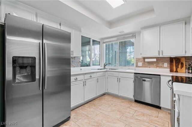 2479 Domingo St, Las Vegas, NV 89121 - kitchen featuring appliances with stainless steel finishes, a sink, light countertops, tasteful backsplash, and white cabinets
