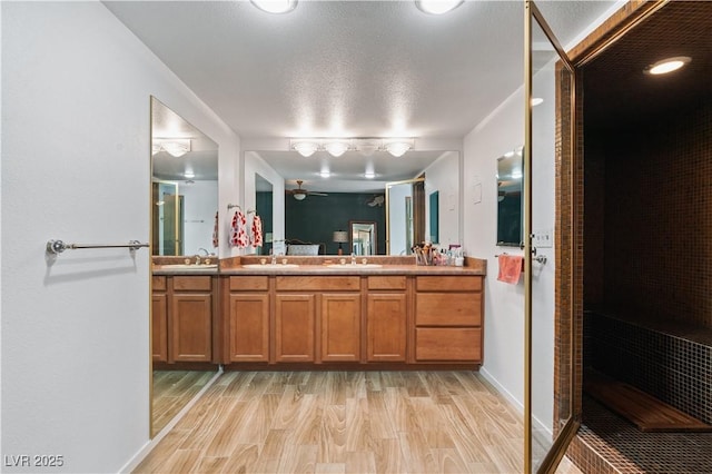 2479 Domingo St, Las Vegas, NV 89121 - bathroom featuring double vanity, a walk in shower, ceiling fan, wood finished floors, and baseboards