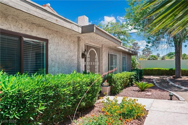 2479 Domingo St, Las Vegas, NV 89121 - view of exterior entry with a chimney and stucco siding