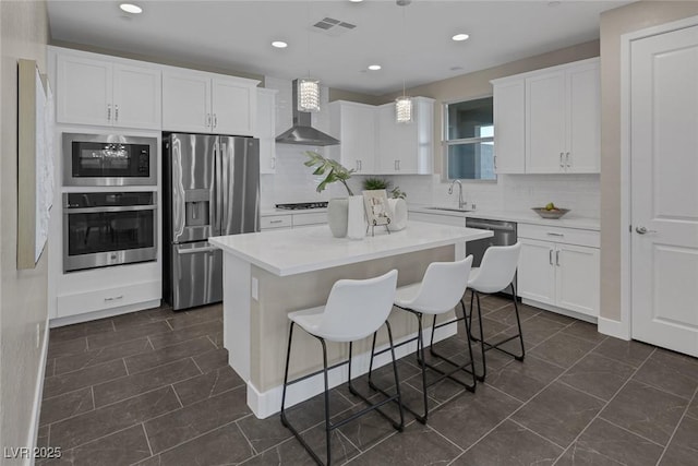 2246 Bird Of Prey St, Las Vegas, NV 89138 - kitchen featuring wall chimney exhaust hood, appliances with stainless steel finishes, a sink, white cabinets, and decorative backsplash