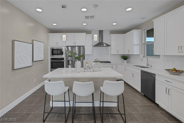 2246 Bird Of Prey St, Las Vegas, NV 89138 - kitchen with stainless steel appliances, wall chimney range hood, a sink, a breakfast bar, and a center island