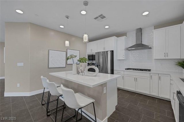 2246 Bird Of Prey St, Las Vegas, NV 89138 - kitchen with appliances with stainless steel finishes, wall chimney range hood, a kitchen island, a kitchen bar, and white cabinetry