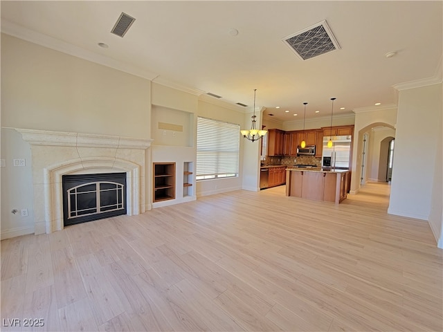 unfurnished living room featuring healthy amount of natural light, baseboards, recessed lighting, and ornamental molding