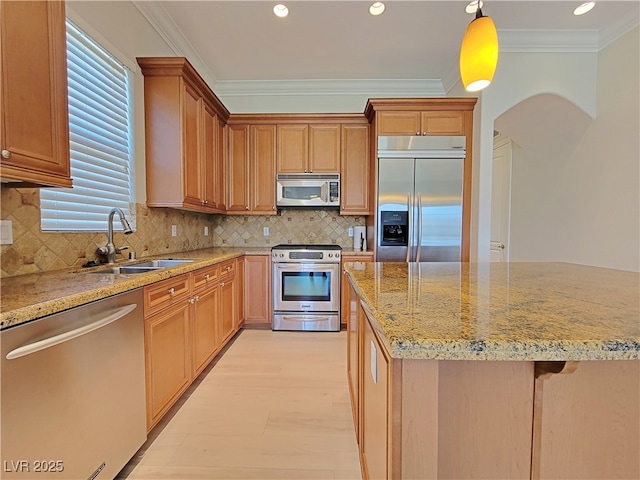 kitchen with stainless steel appliances, a sink, ornamental molding, light stone countertops, and recessed lighting