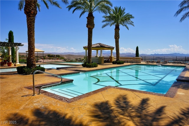 community pool with a gazebo, a mountain view, and a patio