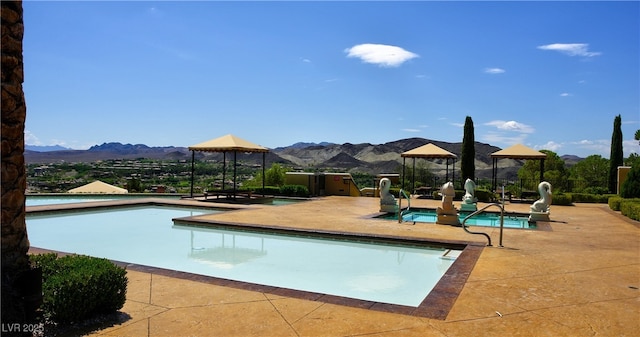 community pool featuring a gazebo, a mountain view, and a patio