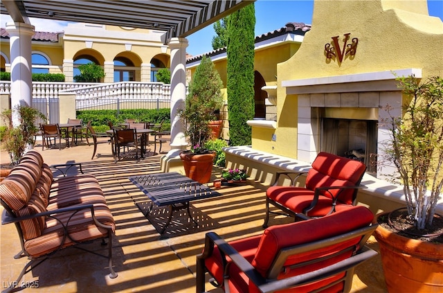 view of patio / terrace with a tile fireplace, a pergola, and outdoor dining area