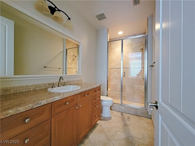 full bath with toilet, a stall shower, vanity, and tile patterned flooring