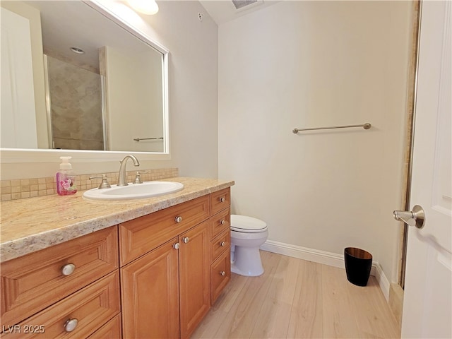 full bath with wood finished floors, toilet, baseboards, and vanity