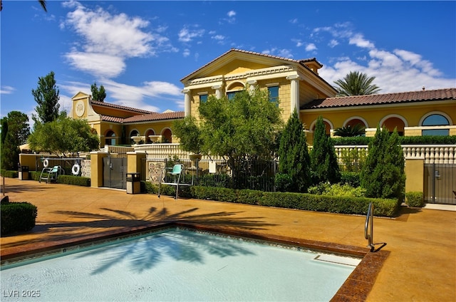 back of property featuring a tiled roof and stucco siding