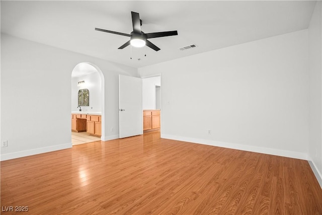 9520 Rancho Palmas Dr, Las Vegas, NV 89117 - unfurnished room with arched walkways, a ceiling fan, light wood-style floors, baseboards, and a sink