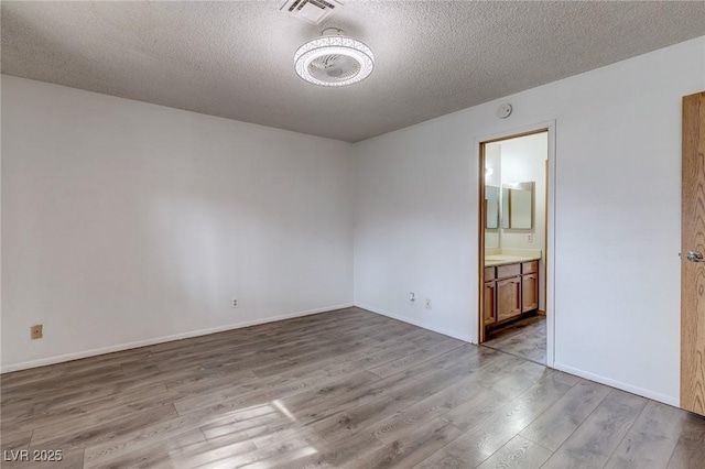 875 Rhinegold Way, Las Vegas, NV 89110 - empty room with a textured ceiling, wood finished floors, and baseboards