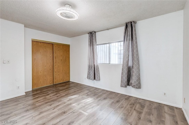 875 Rhinegold Way, Las Vegas, NV 89110 - unfurnished bedroom featuring wood finished floors, a textured ceiling, a closet, and baseboards
