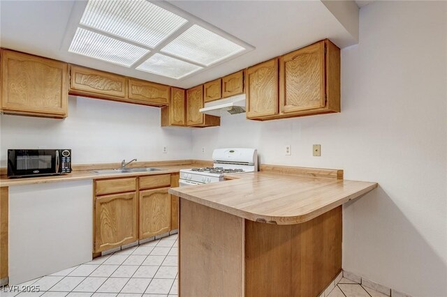 875 Rhinegold Way, Las Vegas, NV 89110 - kitchen with black microwave, white gas range, a sink, light tile patterned floors, and under cabinet range hood