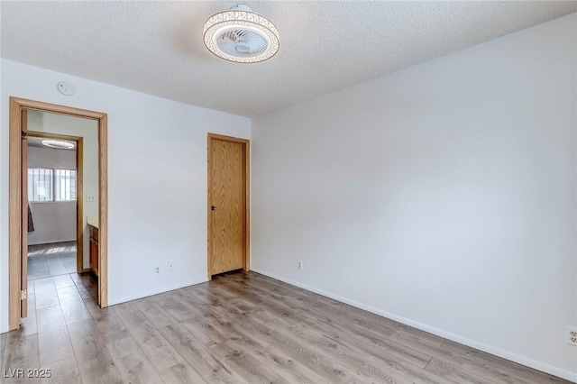 875 Rhinegold Way, Las Vegas, NV 89110 - unfurnished room with light wood-style floors, a smoke detector, baseboards, and a textured ceiling