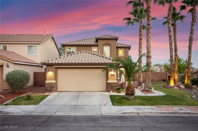 mediterranean / spanish-style house featuring a garage, concrete driveway, stucco siding, and stone siding