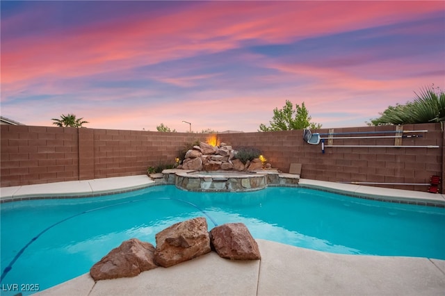 view of pool featuring a fenced backyard and a pool with connected hot tub