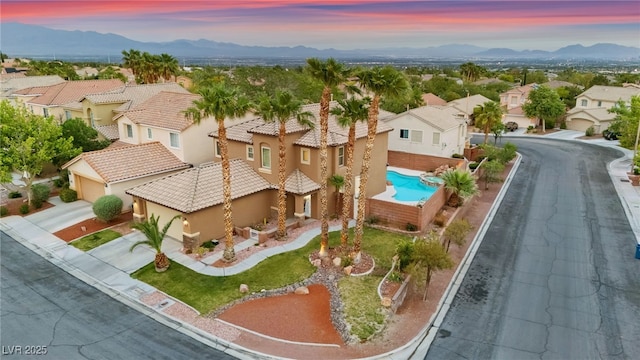 aerial view of residential area with a mountain backdrop and a pool