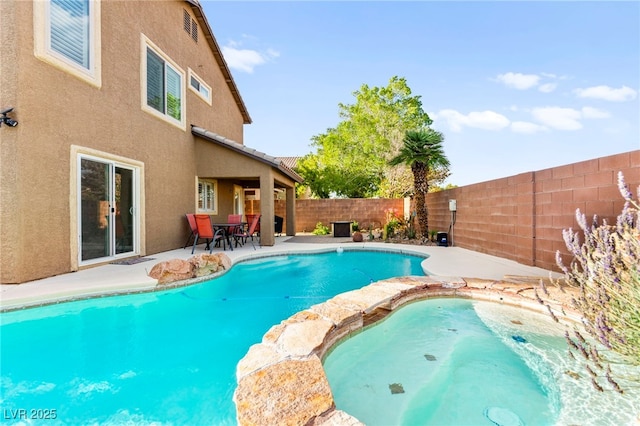 view of pool with a fenced backyard, a patio area, and an in-ground hot tub