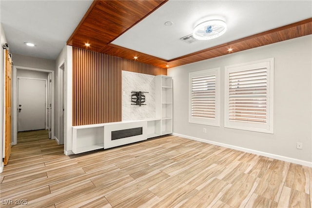unfurnished living room featuring wood finished floors and baseboards
