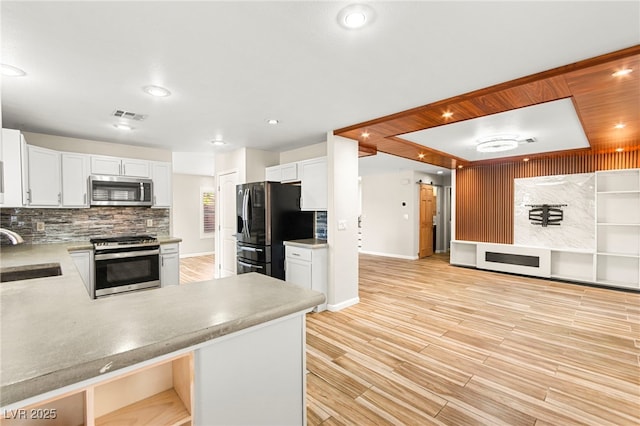 kitchen with stainless steel appliances, a sink, light wood-type flooring, tasteful backsplash, and white cabinetry