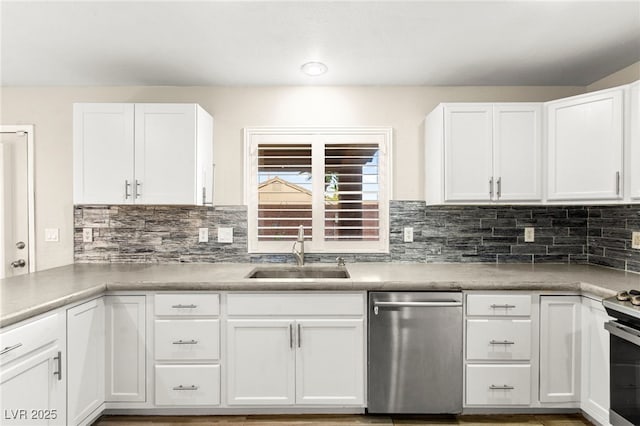 kitchen featuring appliances with stainless steel finishes, a sink, white cabinetry, and backsplash