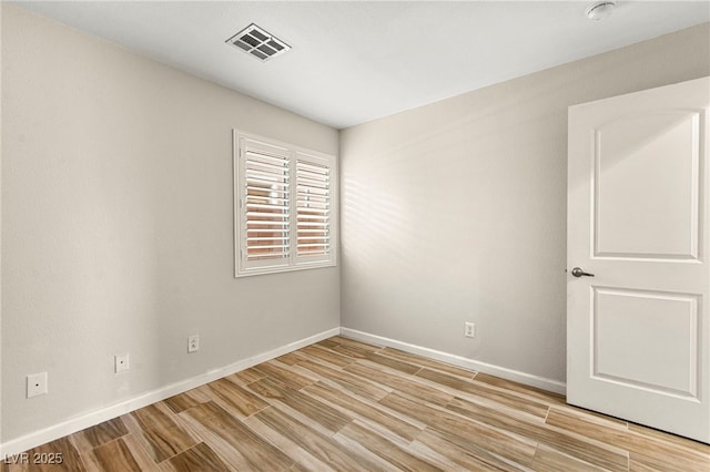 unfurnished room with light wood-style floors, baseboards, and a smoke detector