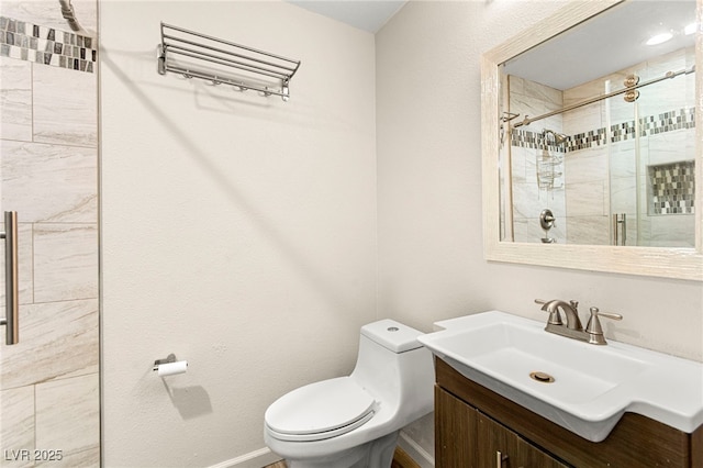 full bathroom with toilet, a stall shower, vanity, and baseboards