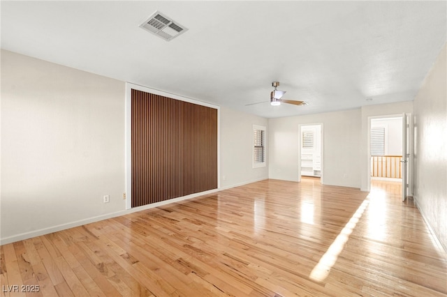 empty room with light wood-style flooring, ceiling fan, and baseboards