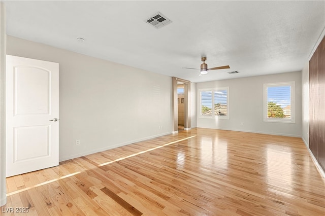 unfurnished room featuring a ceiling fan, light wood finished floors, and baseboards