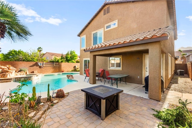 view of pool featuring a fire pit, a fenced backyard, a patio area, and central AC
