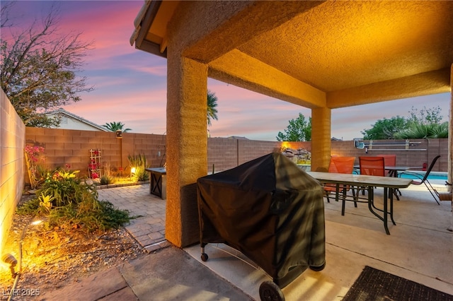 view of patio / terrace with outdoor dining space, a fenced backyard, and a grill