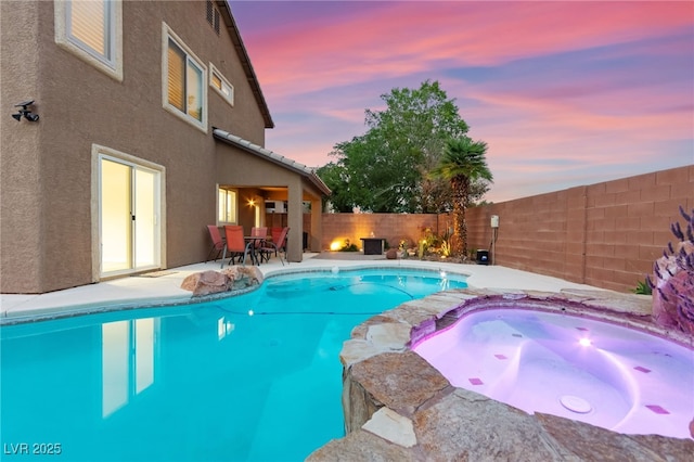 view of swimming pool with an in-ground hot tub, a patio area, a fenced backyard, and outdoor dining space