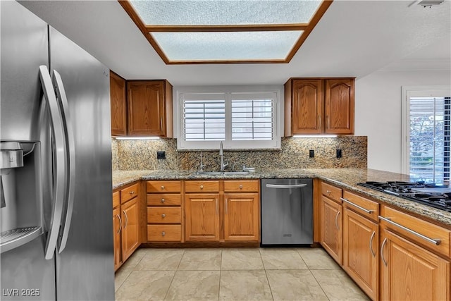8437 Apple Hill Ct, Las Vegas, NV 89128 - kitchen featuring appliances with stainless steel finishes, a sink, brown cabinetry, backsplash, and stone counters