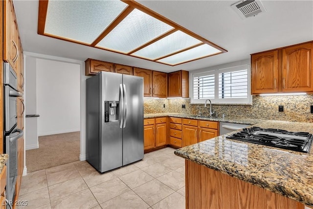 8437 Apple Hill Ct, Las Vegas, NV 89128 - kitchen featuring stainless steel appliances, a sink, brown cabinets, and light stone countertops