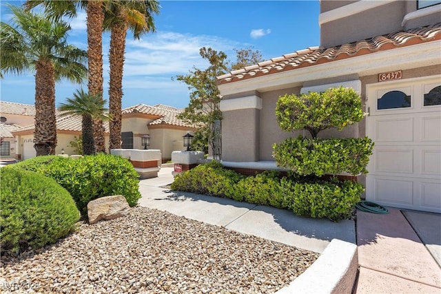 8437 Apple Hill Ct, Las Vegas, NV 89128 - view of property exterior featuring a tile roof, stucco siding, and a garage