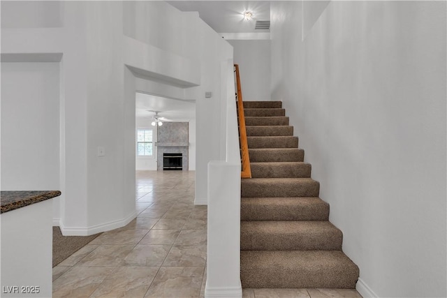 8437 Apple Hill Ct, Las Vegas, NV 89128 - staircase with ceiling fan, baseboards, a large fireplace, and tile patterned flooring