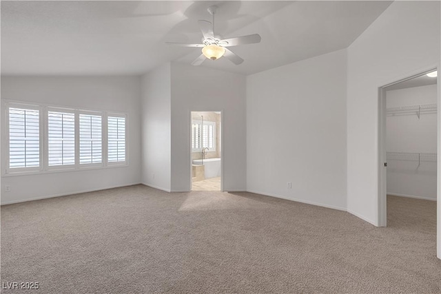 8437 Apple Hill Ct, Las Vegas, NV 89128 - unfurnished bedroom featuring lofted ceiling, light colored carpet, a walk in closet, a closet, and baseboards