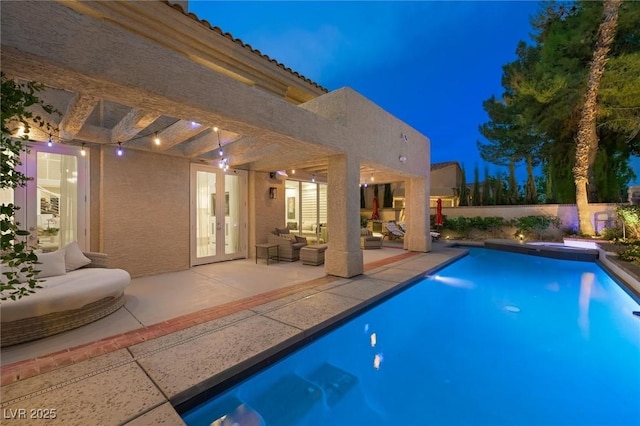 5125 Turnberry Ln, Las Vegas, NV 89113 - pool at night with an outdoor living space, a patio area, and french doors