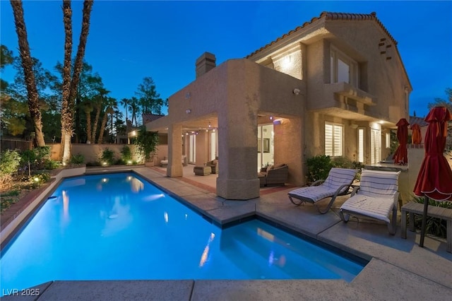 5125 Turnberry Ln, Las Vegas, NV 89113 - back of house at twilight with a patio, a fenced backyard, an outdoor living space, and stucco siding
