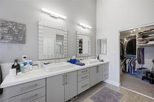 5125 Turnberry Ln, Las Vegas, NV 89113 - bathroom featuring double vanity, wood finished floors, a spacious closet, and a high ceiling