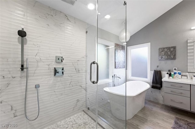5125 Turnberry Ln, Las Vegas, NV 89113 - full bath featuring a marble finish shower, a freestanding tub, vanity, vaulted ceiling, and wood finished floors