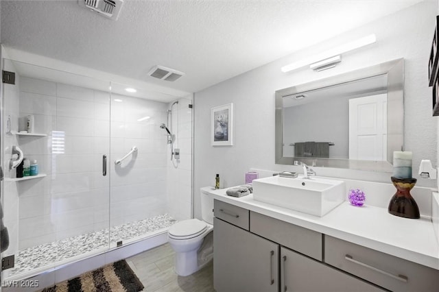 5125 Turnberry Ln, Las Vegas, NV 89113 - full bath featuring toilet, a shower stall, a textured ceiling, vanity, and wood finished floors