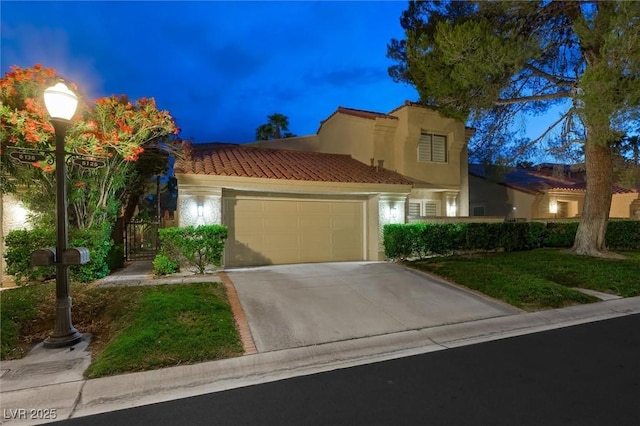 5125 Turnberry Ln, Las Vegas, NV 89113 - mediterranean / spanish-style home featuring a tiled roof, stucco siding, an attached garage, and driveway