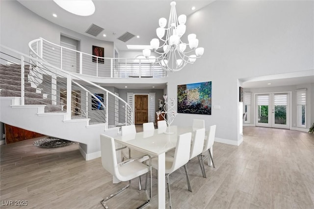 5125 Turnberry Ln, Las Vegas, NV 89113 - dining area with a high ceiling, stairway, a chandelier, wood finished floors, and baseboards