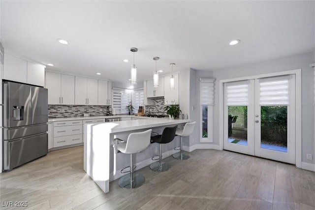 5125 Turnberry Ln, Las Vegas, NV 89113 - kitchen featuring stainless steel fridge, light countertops, white cabinetry, tasteful backsplash, and recessed lighting